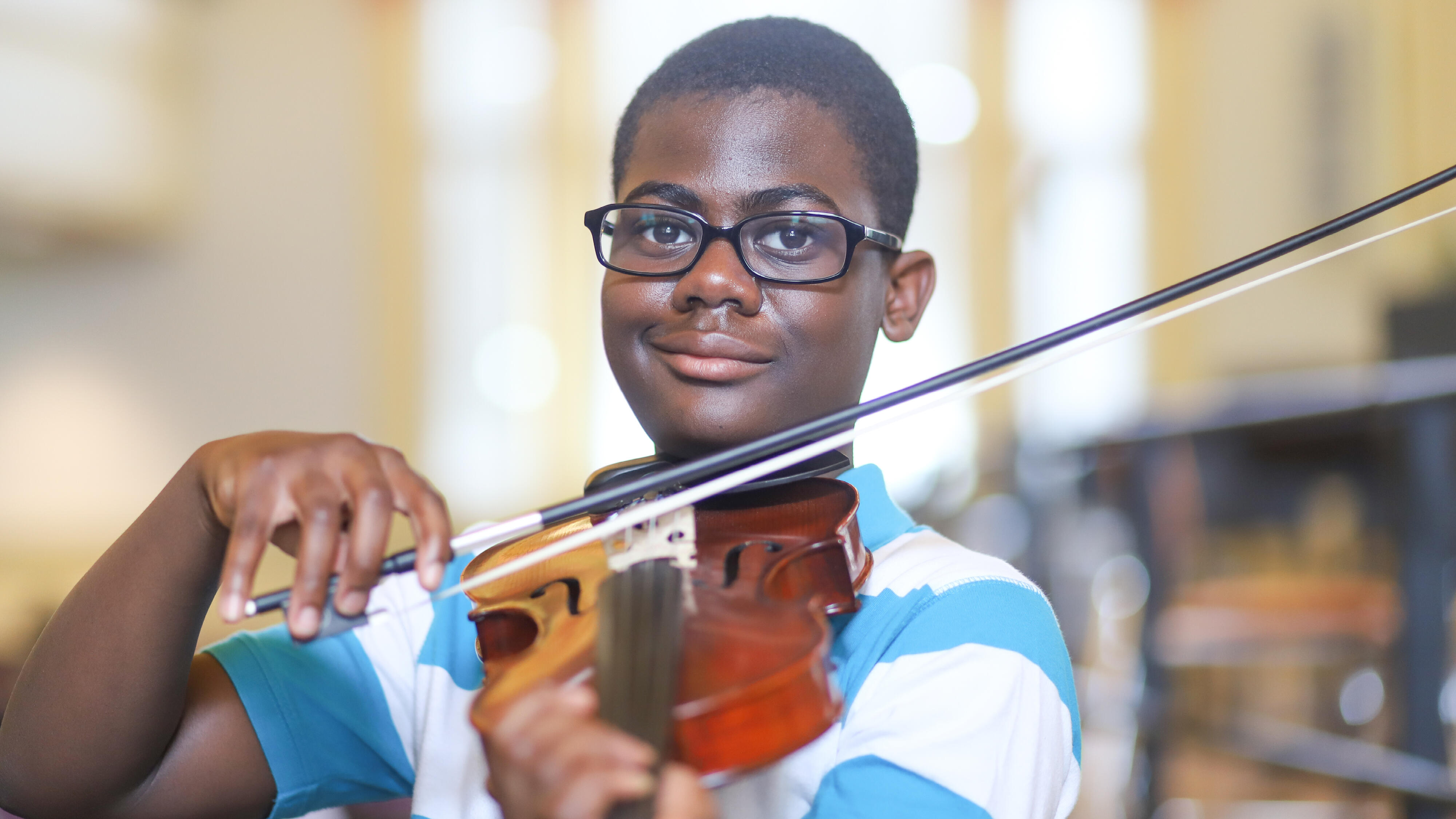Student smiling while playing the violin