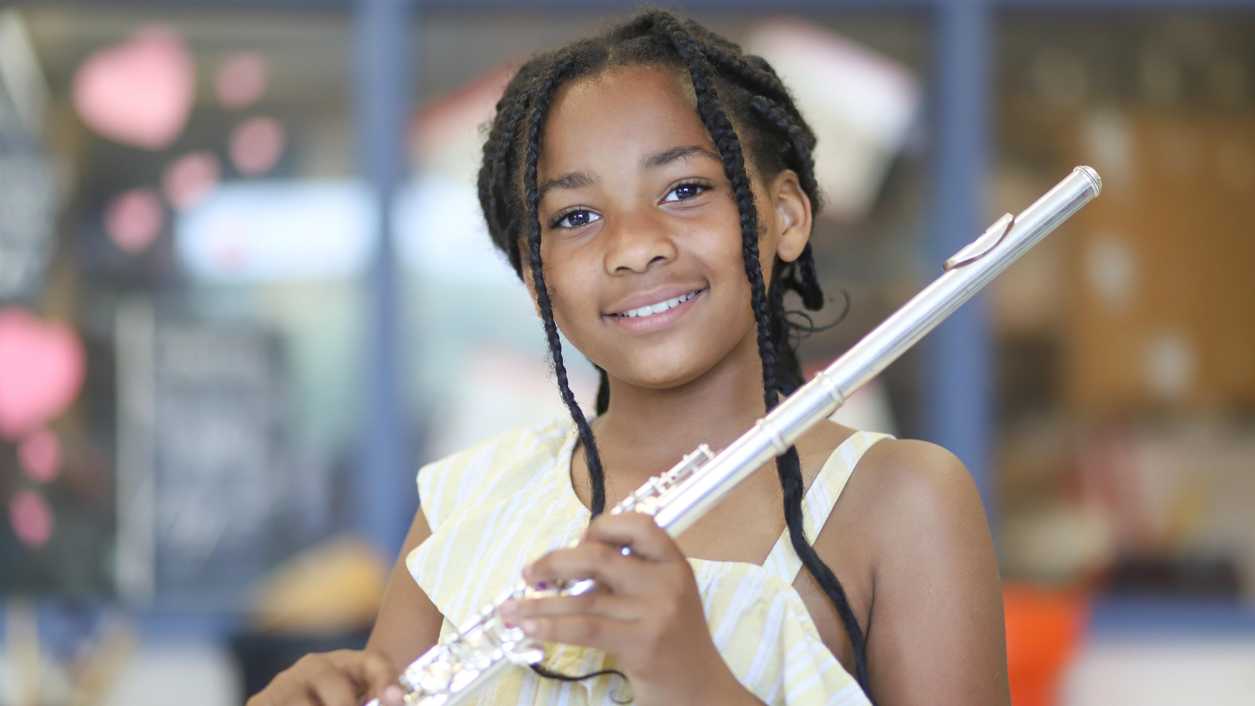 Student smiling and holding a flute
